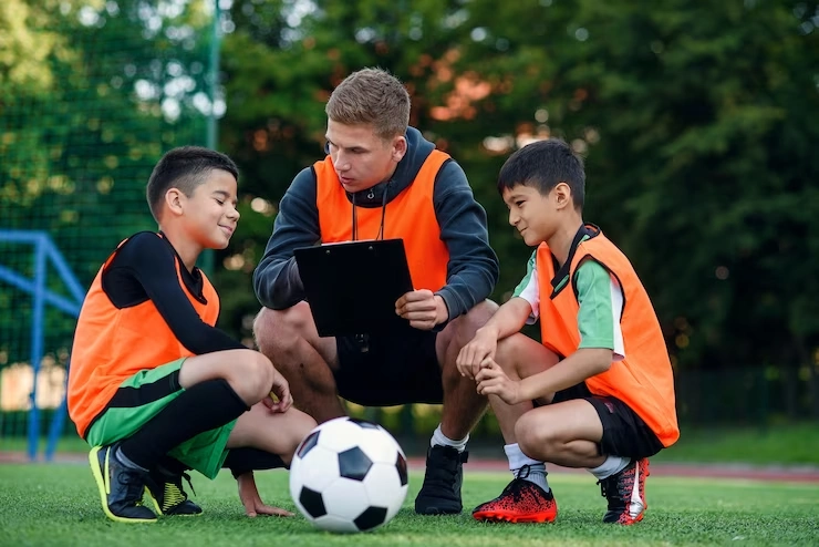 soccer coach shows football strategy game to players during training